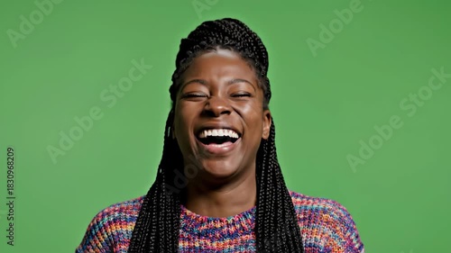 Woman Laughing Joyfully Against Green Backdrop