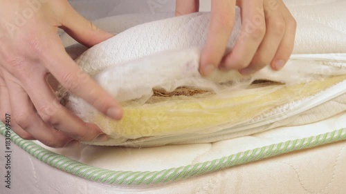 Hand is touching mattress inner filled with coconut chips. Firm orthopedic mattress topper. Close up, 4k footage.