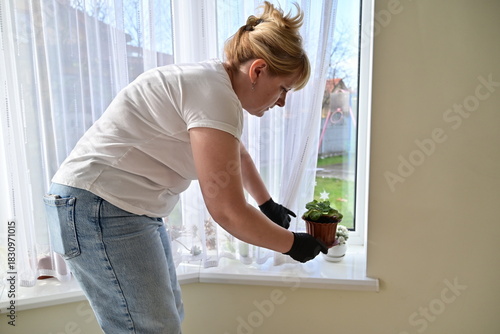 Woman checking plant leaves during indoor plant care