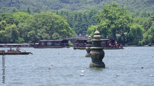 Three Pools Mirroring Moon stone pagoda at West Lake Hangzhou China with traditional boats and mountain landscape