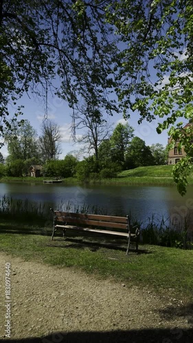 Pond in a green park. Ancient castle against a blue sky with clouds. A popular holiday destination for Baltic tourists. Jaunmoku. Latvia
