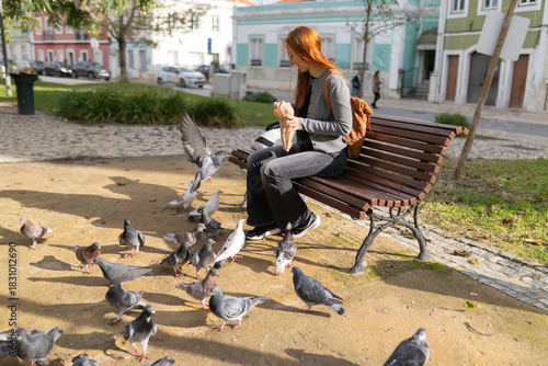 Woman feeding pigeons in urban city park