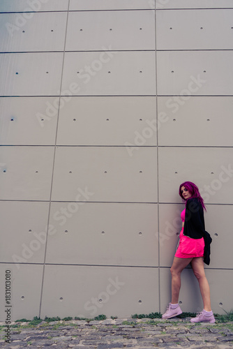 Woman with magenta hair posing in urban setting