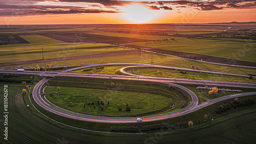 Fotografie Aerial sunset view of a highway interchange with smooth looping curves