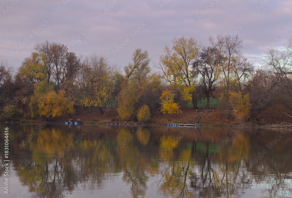 Fototapeta premium Trees in autumn colors reflected in the water