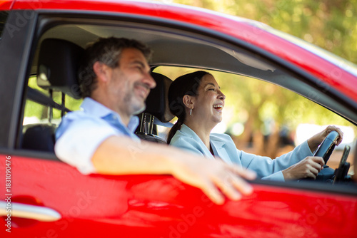 Couple laughing together during drive in red car
