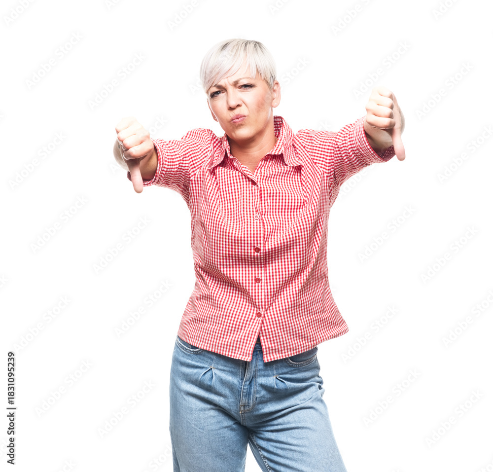 Obraz premium Displeased middle aged woman showing thumbs down, isolated on white background. Dislike or negative concept.
