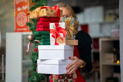 Woman holding large stack of christmas presents