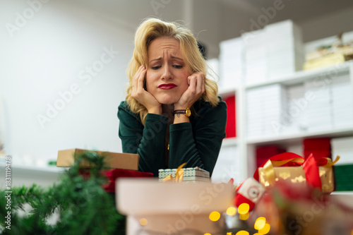 Woman feeling stressed by christmas gift wrapping preparations