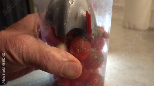 Stockholm, Sweden A cook uses a hand blender to blend fresh tomatoes with spices and garlic for a pizza sauce. 