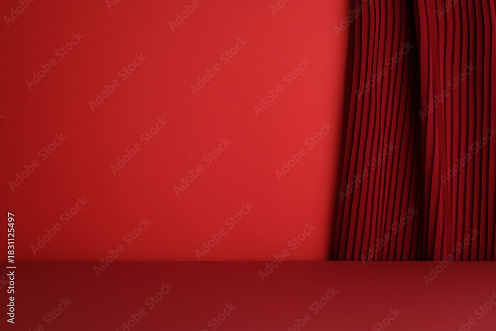 Obraz premium Simple, empty red studio stage with a dark red pleated curtain on the right side.