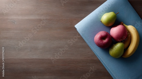 Fototapeta Naklejka Na Ścianę i Meble -  Healthy lifestyle concept with fresh fruits and yoga mat on wooden floor, high-resolution