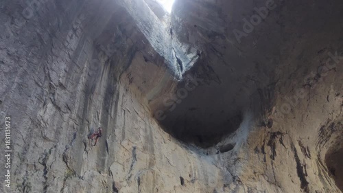 A man climbing inside a big cave