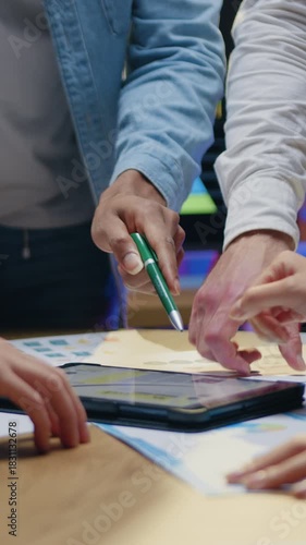 Unknown man and woman specialists standing behind work desk and discussing joint business concept using information from tablet pc