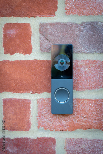 Modern doorbell on red brick house in London