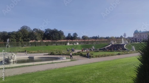 Many people in the garden of the Belvedere Palace between fountains