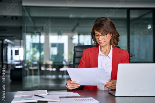 Quadro su tela Focused business woman saleswoman working on laptop computer reading analysing financial loan contract document in office
