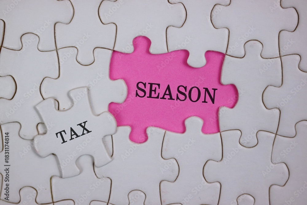 Fototapeta premium Close-up of puzzle pieces, featuring a pink piece labeled SEASON beside a white piece labeled TAX. Symbolizes the link between tax season and personal or business finances.