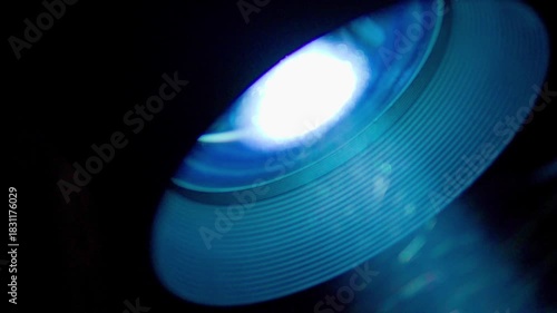 Projector lens emitting bright blue light beam