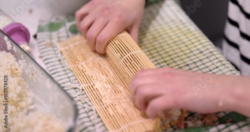 Rolling California rolls in a home Kitchen using a bamboo Mat in broad daylight