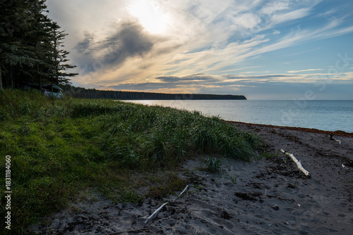Calm Ocean, Low Tide, Wet Rocks, Seaweed Patterns, and Overcast Sky at Sunset Creating a Minimalist Coastal Landscape in Grand Makasti, Anticosti Island, Quebec, Canada