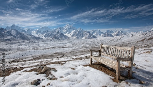 Solitary wooden bench overlooks vast snow-covered glacial valley beneath towering icy peaks