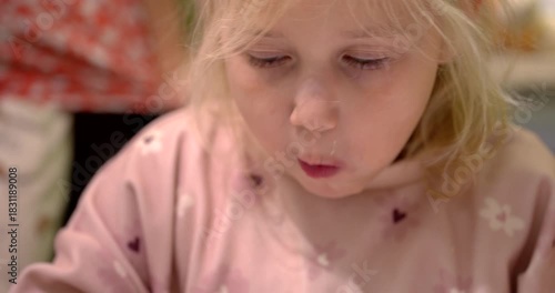 Little one tries a new food at the kitchen table during daytime, making funny face expressions
