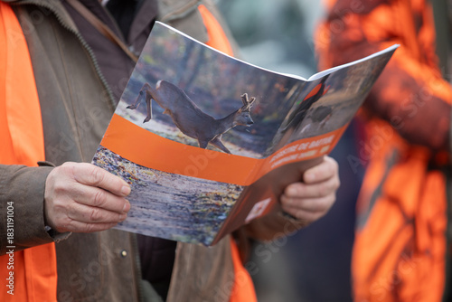 Hunter reading deer hunting brochure in the field
