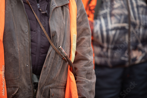 Hunter wearing safety vest with hunting horn during briefing