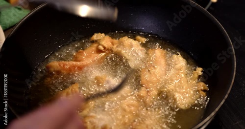 Crispy chicken tenders sizzling in hot oil on a stove during a late afternoon snack time