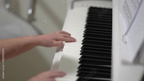 Hands practicing scales on a white keyboard for classical music education