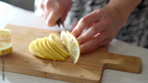 Slicing lemons on a wooden board in a sunlit kitchen, preparing fresh fruit for a morning recipe
