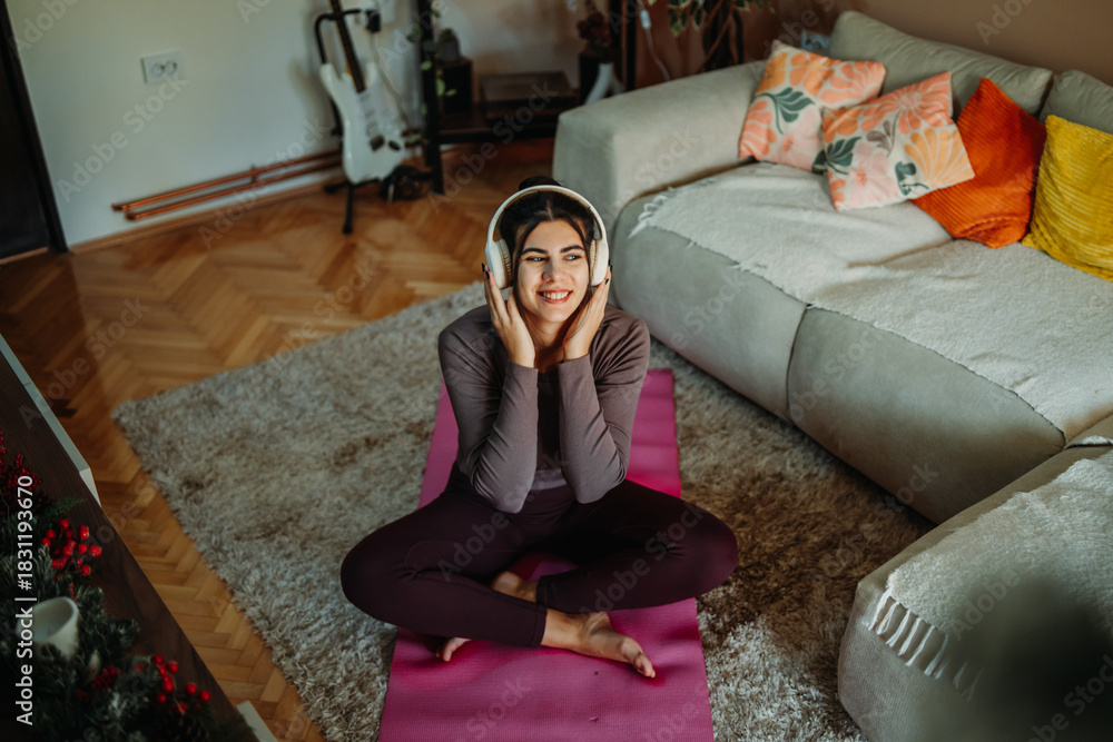 Obraz premium Woman relaxing at home, enjoying music with headphones