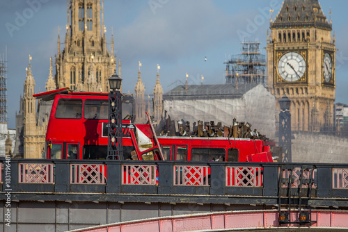 LONDON, UK -  7 2016.  A dramatic scene unfolds as a red double-decker bus explodes on Lambeth Bridge, with the iconic Parliament buildings in the background. 