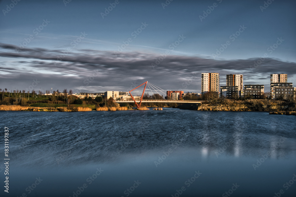 Obraz premium Red Suspension Bridge Over Pae Lake at Sunset with Long Exposure Water Effect
