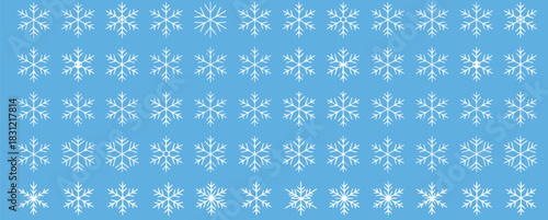 Delicate snowflakes falling gently on a light blue background creating a winter wonderland, ideal for holiday cards and festive season designs