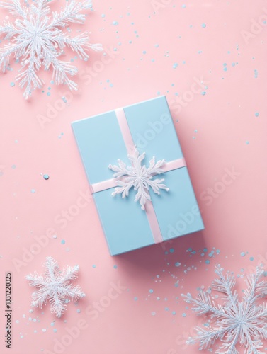 Elegant winter gift box on pastel pink background with snowflake decorations for holiday celebration