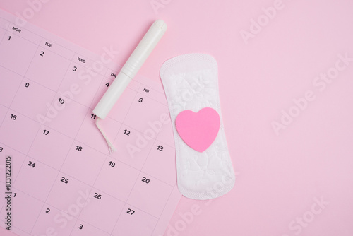 Menstrual cycle tracking calendar with sanitary products and  pink heart 