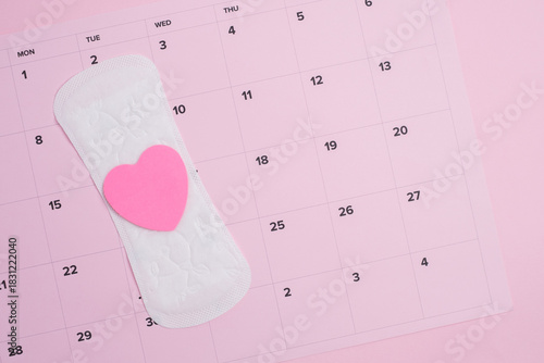 Menstrual cycle tracking calendar with sanitary products and  pink heart 