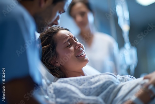 Distressed woman in a hospital bed with medical staff nearby, symbolizing intense labor pain, a medical emergency, childbirth crisis, or miscarriage.