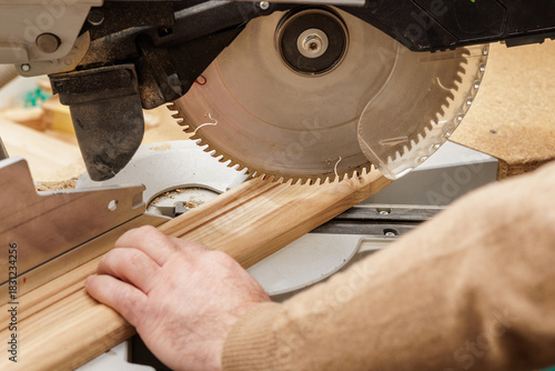 Obraz na plátně Close up of miter saw cutting wood trim in carpentry workshop