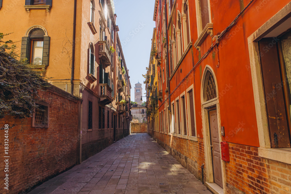 Fototapeta premium Narrow street alley in Venice Italy with historic architecture