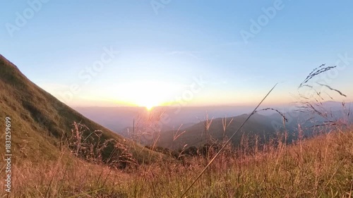 4k sunset blue sky scene on the top of mountain with grass foreground