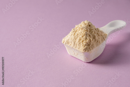Spoon with protein on colored background.