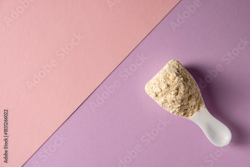 Spoon with protein on colored background.