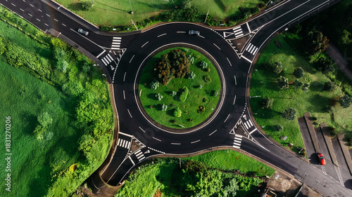 Tableau sur toile Aerial view of a circular traffic roundabout surrounded by lush greenery and lan