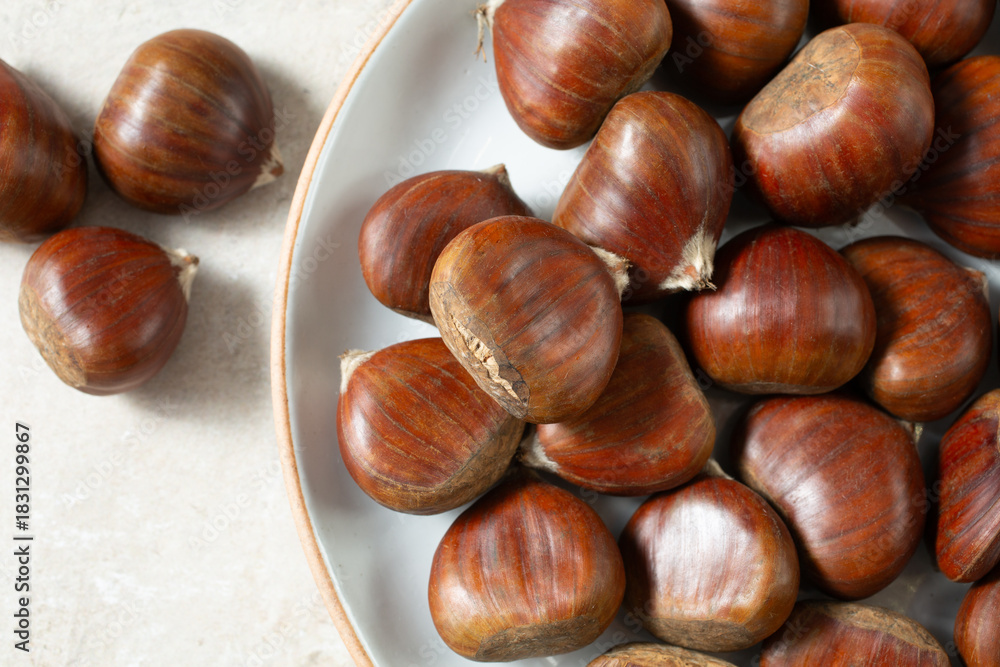 Obraz premium A top down view of a layer of chestnuts, on a plate.
