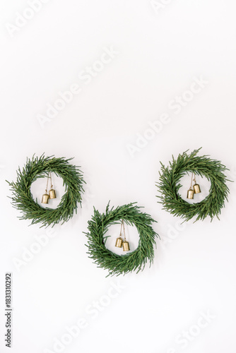 Minimalist Christmas Greenery Wreaths with Gold Bells on White Wall Holiday Decor