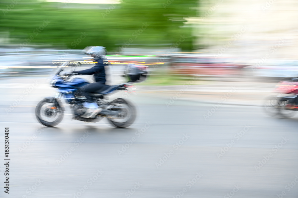Obraz premium Blurred motorcycle is moving fast on the street. The driver drives his motorcycle fast in the city. High speed motorbike rider. 