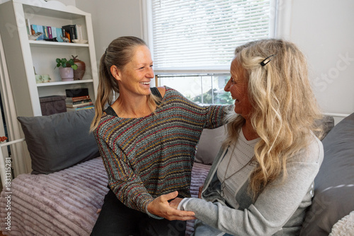Two friends having a candid and joyous conversation indoors 